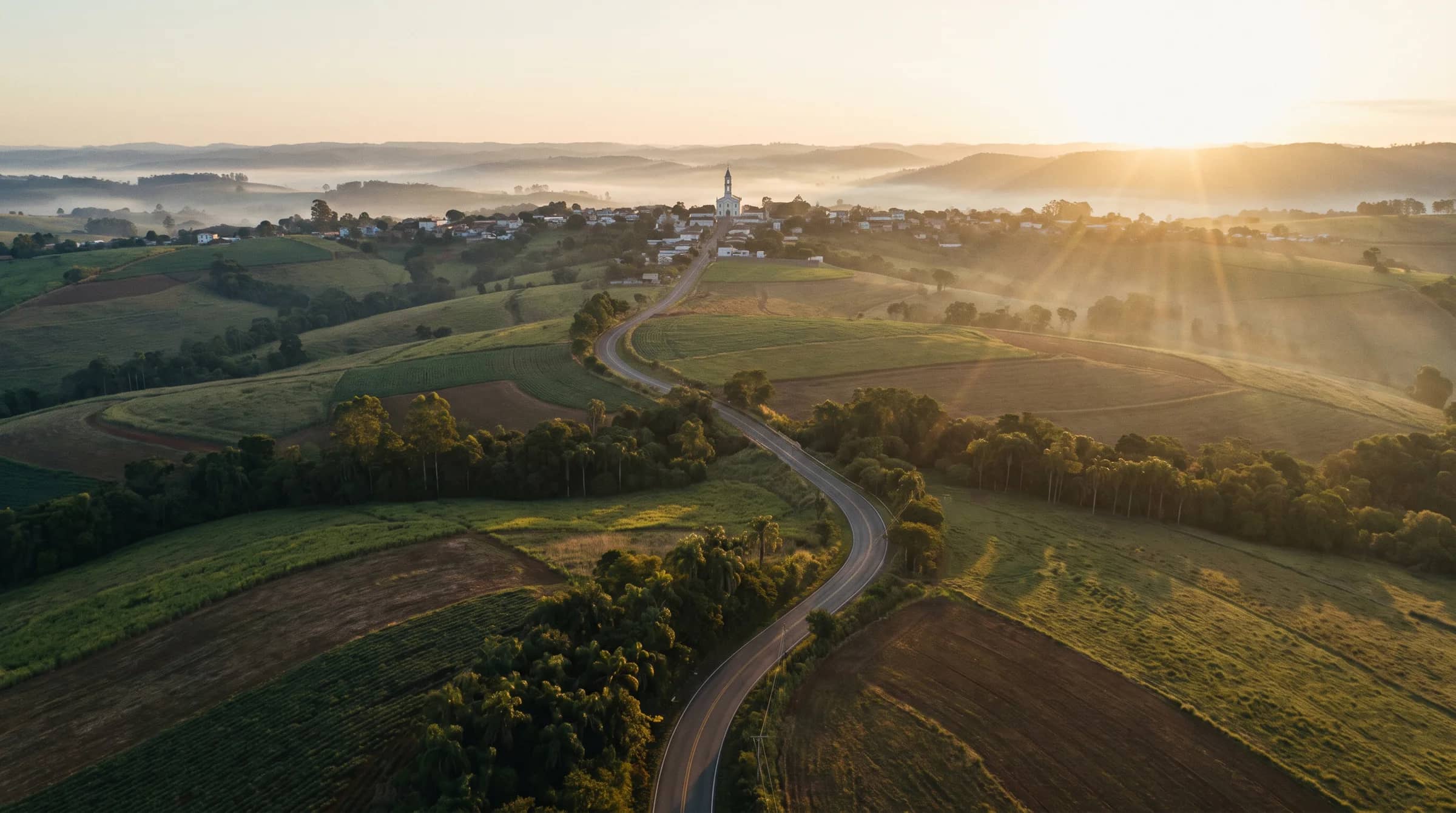 Vista aérea de campos e cidade do interior ao amanhecer