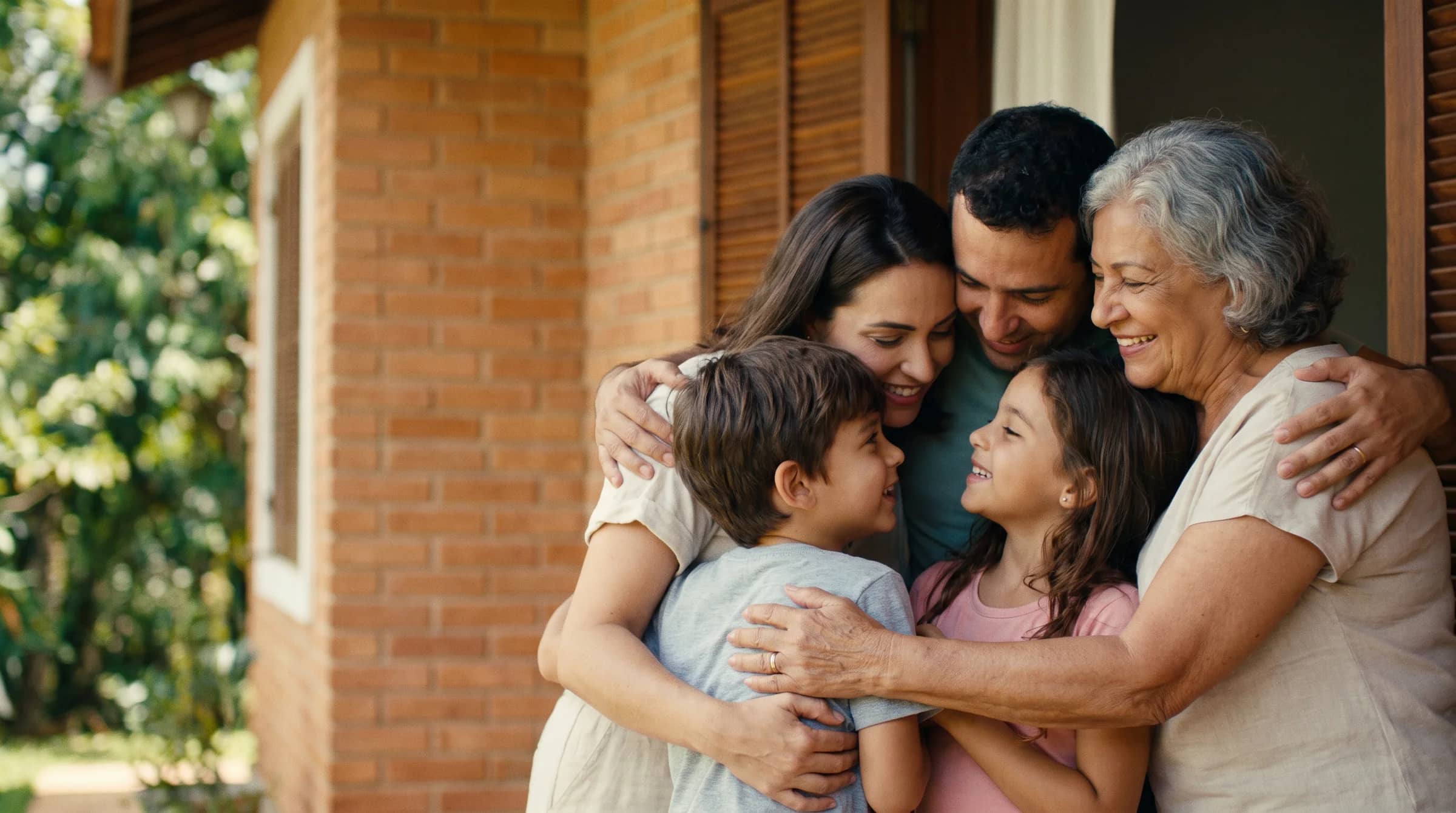 Família reunida e abraçada na varanda de casa