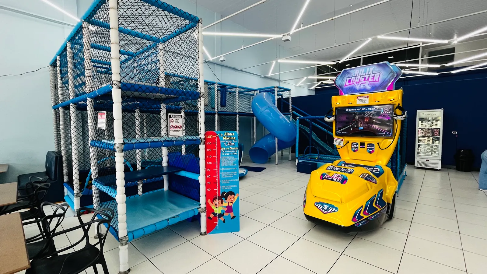 Playground azul e fliperama no espaço kids da Skimo