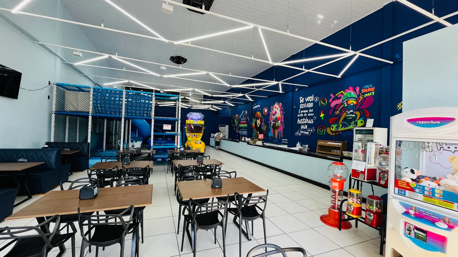 Salão amplo com mesas e iluminação de LED
